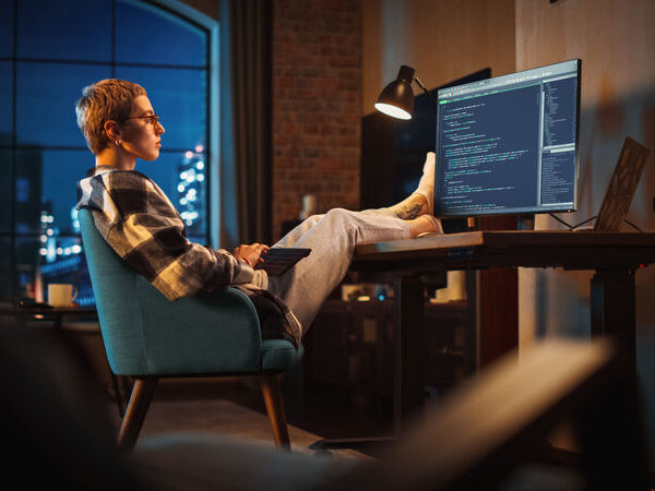computer programmer, laid back in chair writing html code