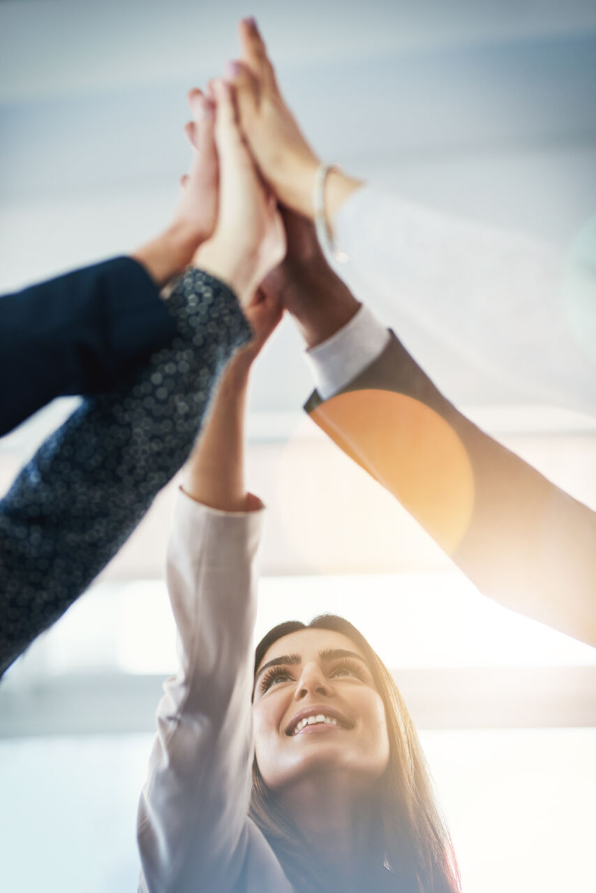 Cropped shot of group of businesspeople gathering for a high five