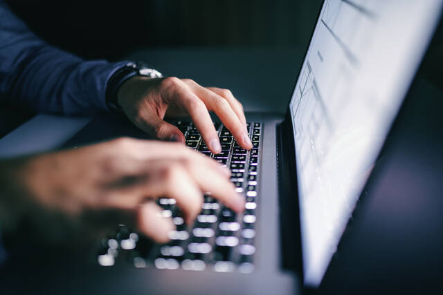 hands typing on a laptop keyboard